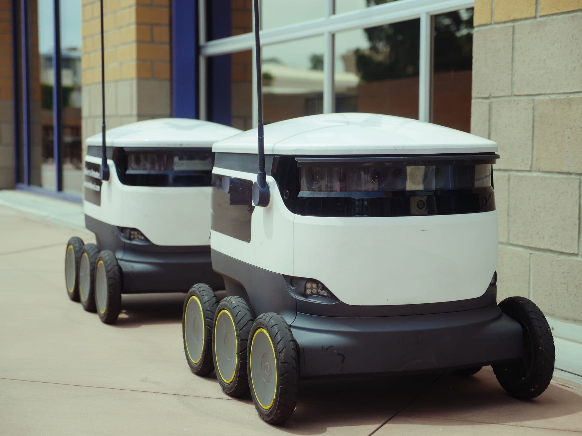 Two autonomous delivery robots operating side by side